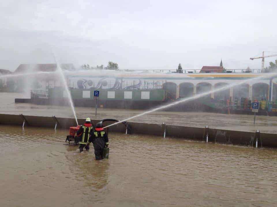 Die Werftstraße am Dienstagmorgen: Die Feuerwehr kämpft mit Pumpen gegen die Wassermassen, welche die Schutzwände überspült haben.