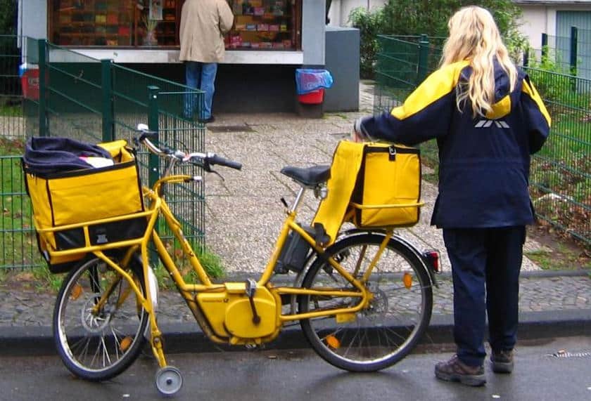 Auf ihrem Rücken erfüllt die Deutsche Post Renditeversprechen an ihre Aktionäre: Brief- und Paketzusteller. Foto: Wikimedia Commons