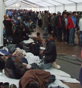 Essensausgabe im Flüchtlingszelt am Grenzübergang Wegscheid. Wartende schlafen auf Decken am Holzboden. 