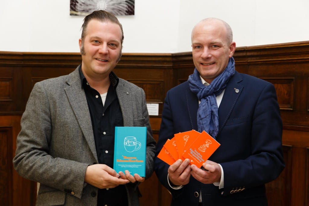 Regensburg-Anekdoten und allerlei Weisheiten im Kleinformat: Autor und Verleger Philipp Starzinger (links) bei der Übergabe seines Büchleins an OB Joachim Wolbergs. Foto: Stadt Regensburg/Stefan Effenhauser