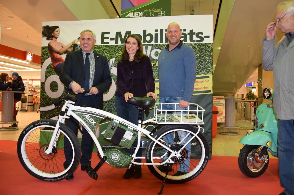 Bürgermeister Jürgen Huber (Bündnis 90 / Die Grünen), Center Managerin Sibylle Wunderlich und Peter Oppermann, Vertriebsleiter der BAYK AG zur Eröffnung der Mobilitätsmesse. Das nagelneue E-Bike geht jetzt an den DrugStop Drogenhilfe Regensburg e.V. Foto: Alex-Center