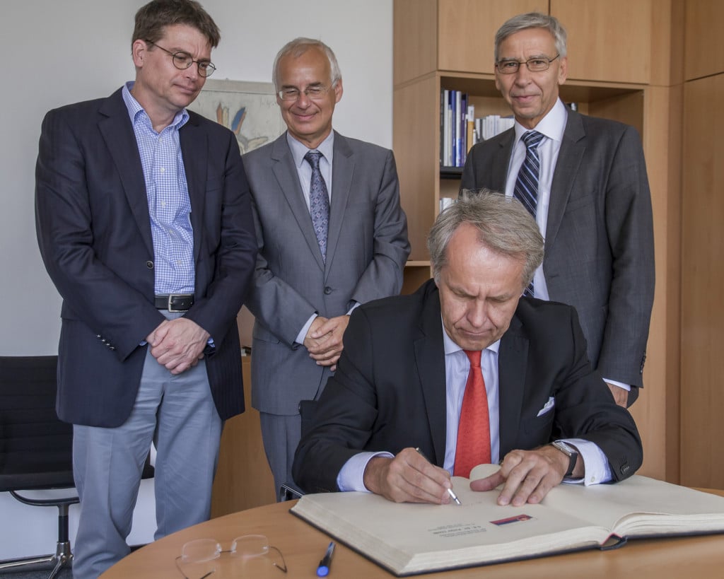 S.E. Dr. Peter Lizák, Botschafter der Slowakischen Republik, trägt sich in das Gästebuch der Universität Regensburg ein; hinten (v.l.n.r.) Prof. Dr. Volker Depkat, Prof. Dr. Walter Koschmal, Präsident Prof. Dr. Udo Hebel. Bildnachweis: Universität Regensburg, Referat II/2, Sarah Rohrer